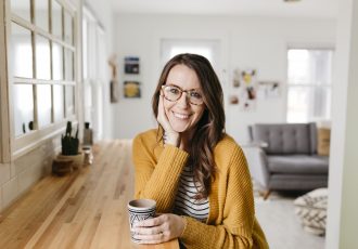 woman wearing reading glasses with cup of coffee