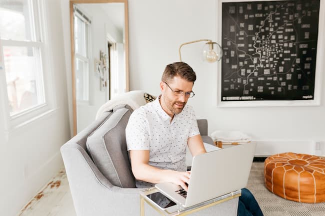 man on couch working on laptop